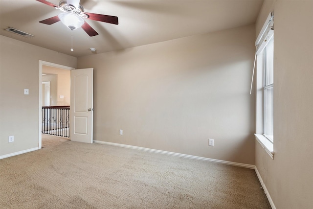 spare room featuring ceiling fan and light carpet