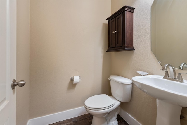 bathroom with sink, toilet, and hardwood / wood-style flooring