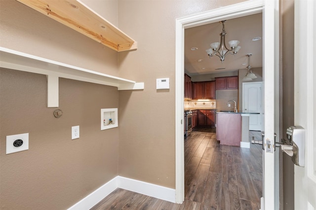 washroom with sink, washer hookup, dark wood-type flooring, an inviting chandelier, and electric dryer hookup