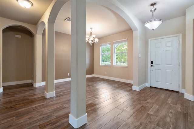 entrance foyer featuring dark wood-type flooring and an inviting chandelier