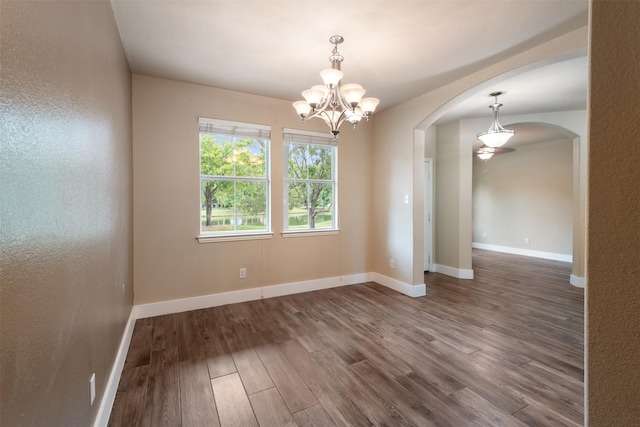 unfurnished room with wood-type flooring and an inviting chandelier