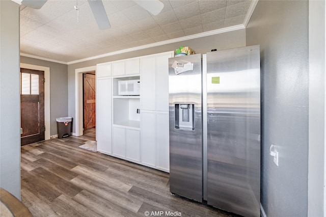 kitchen with crown molding, white cabinetry, white microwave, wood-type flooring, and stainless steel fridge with ice dispenser