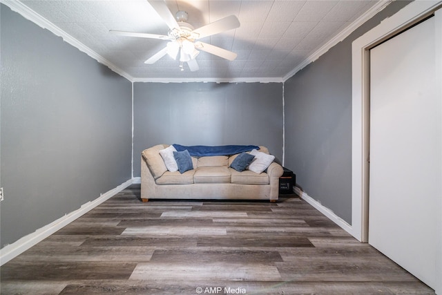 living area with ornamental molding, dark hardwood / wood-style floors, and ceiling fan