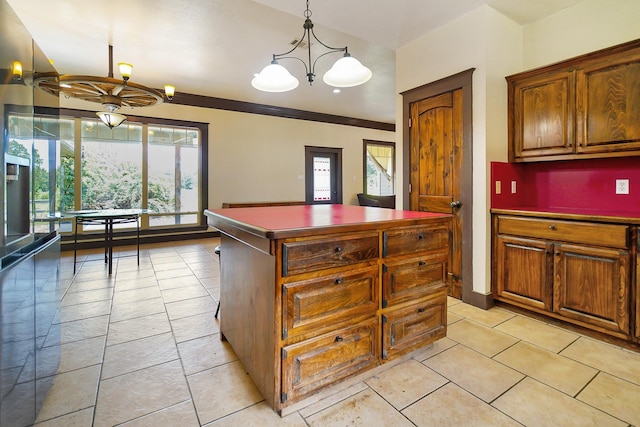 kitchen featuring light tile patterned floors, an inviting chandelier, hanging light fixtures, dark countertops, and a center island