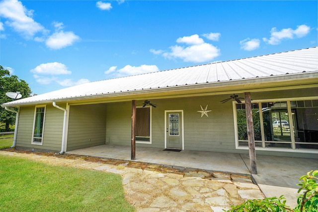 rear view of property with ceiling fan, a lawn, and a patio