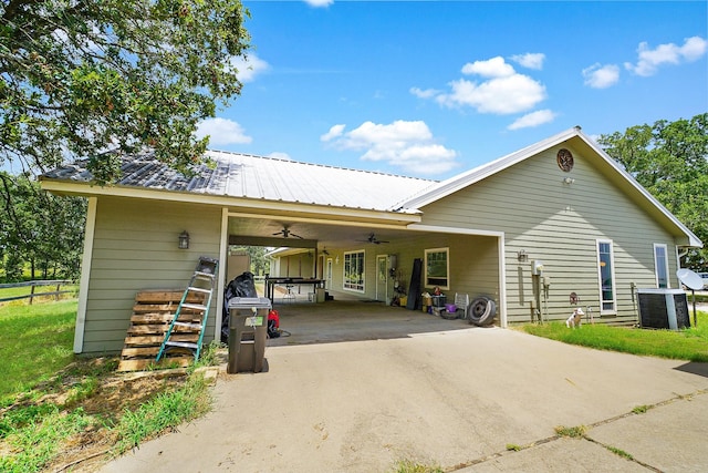 exterior space with an attached carport, ceiling fan, concrete driveway, central air condition unit, and metal roof