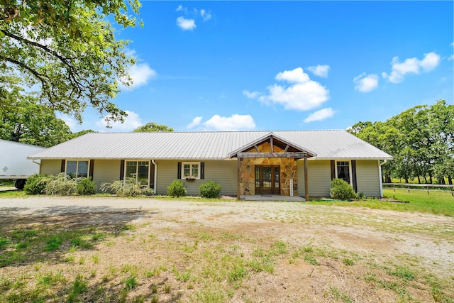 ranch-style home featuring french doors and metal roof