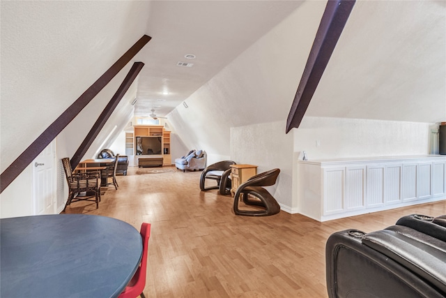 interior space with light hardwood / wood-style floors and vaulted ceiling