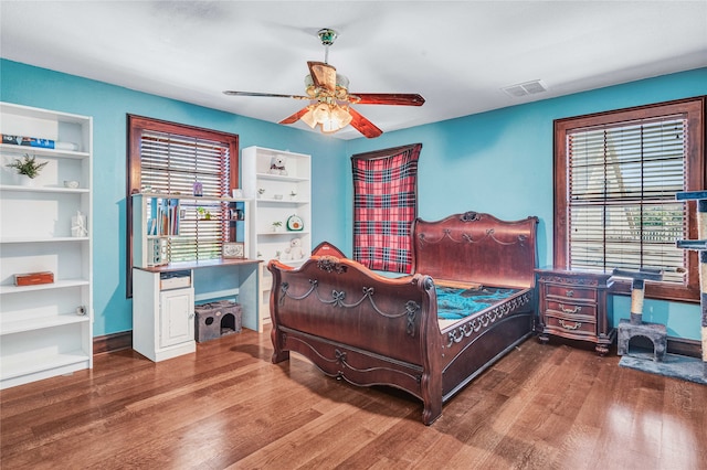 bedroom with multiple windows, ceiling fan, and hardwood / wood-style floors