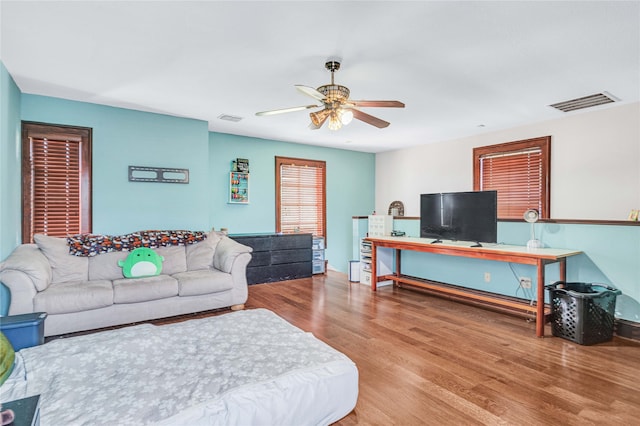 living room with wood-type flooring and ceiling fan