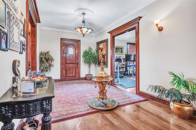 entryway with wood-type flooring and crown molding