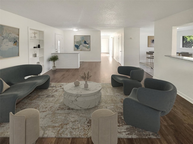 living room featuring hardwood / wood-style flooring, built in features, and a textured ceiling