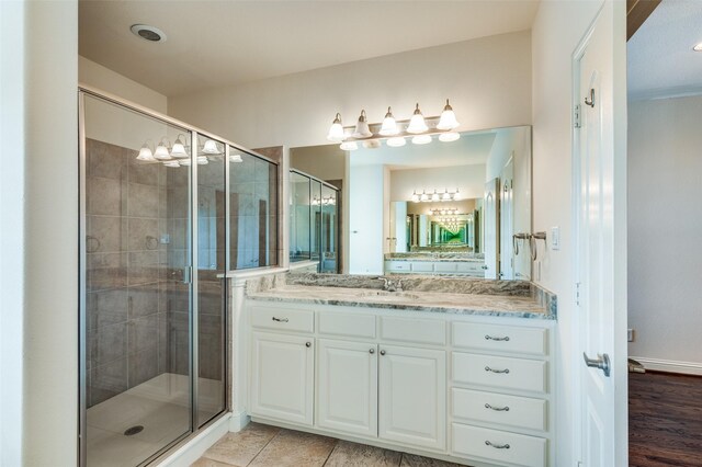 bathroom with hardwood / wood-style floors, vanity, and an enclosed shower