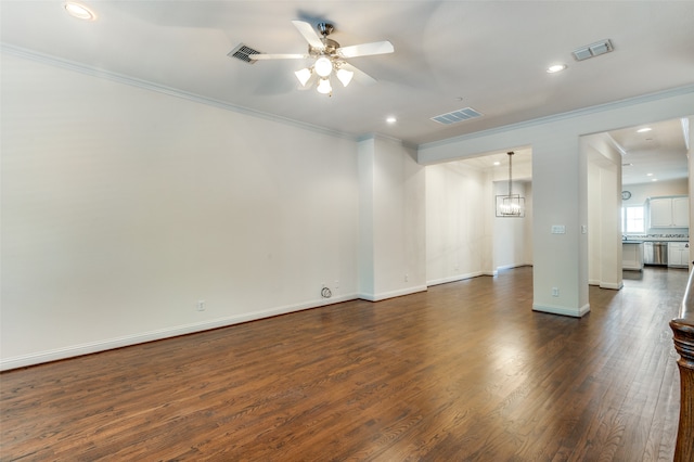 unfurnished room with dark hardwood / wood-style floors, ceiling fan with notable chandelier, and crown molding