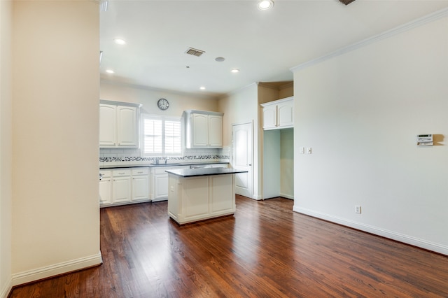 kitchen with a center island, decorative backsplash, dark hardwood / wood-style flooring, and white cabinets