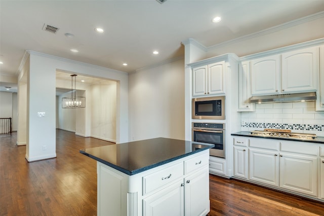 kitchen featuring tasteful backsplash, decorative light fixtures, dark hardwood / wood-style flooring, stainless steel appliances, and white cabinets