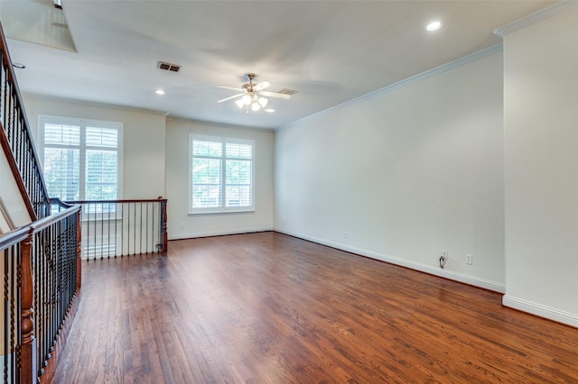 empty room with crown molding, dark wood-type flooring, and ceiling fan