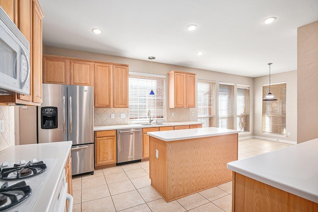 kitchen featuring a wealth of natural light, a kitchen island, hanging light fixtures, and appliances with stainless steel finishes