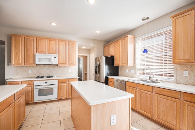 kitchen with a center island, sink, stainless steel appliances, decorative light fixtures, and light tile patterned flooring