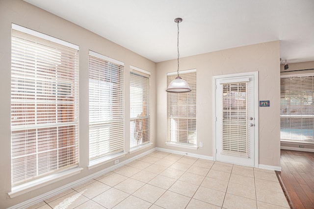 unfurnished dining area featuring a healthy amount of sunlight and light wood-type flooring