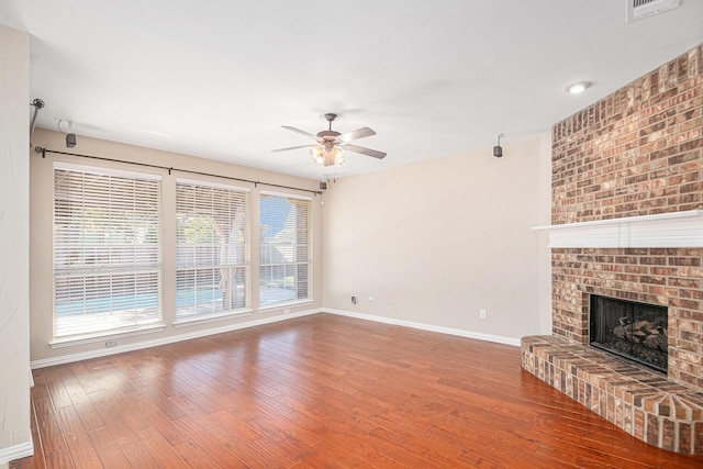 unfurnished living room with ceiling fan, wood-type flooring, and a fireplace