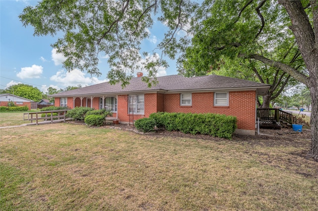 ranch-style house with a deck and a front lawn