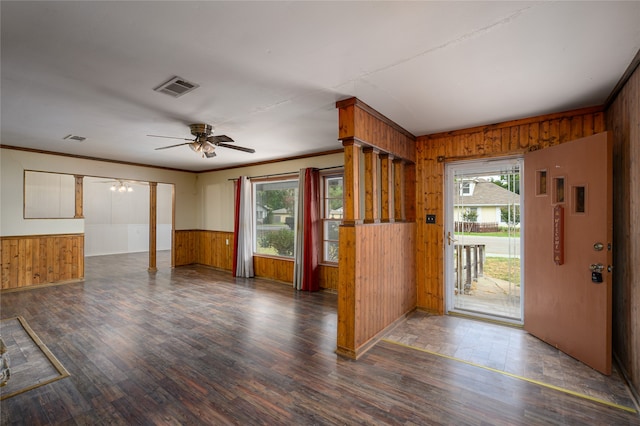 foyer featuring wood walls, ceiling fan, and dark wood-type flooring