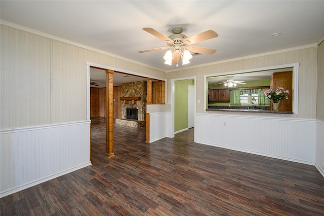 interior space featuring ornamental molding, a stone fireplace, hardwood / wood-style flooring, and ceiling fan