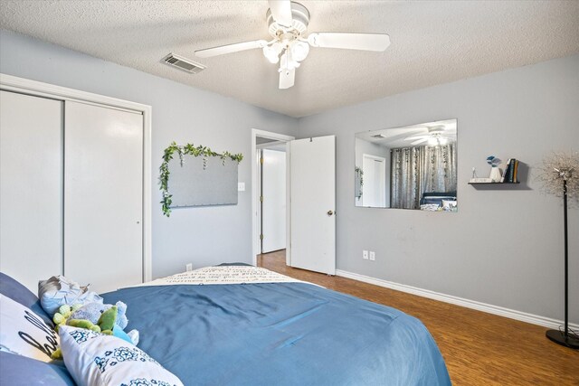 bedroom featuring a textured ceiling, ceiling fan, hardwood / wood-style floors, and a closet