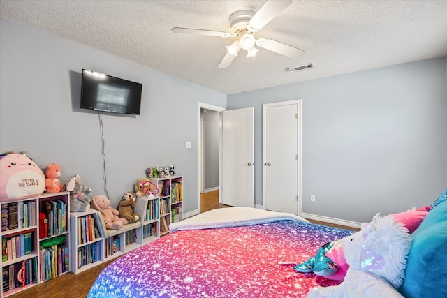 bedroom featuring wood-type flooring, a textured ceiling, and ceiling fan