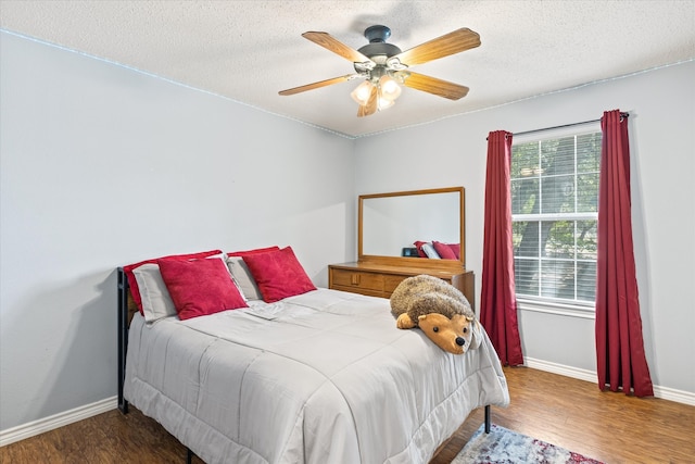 bedroom featuring a textured ceiling, hardwood / wood-style floors, and ceiling fan