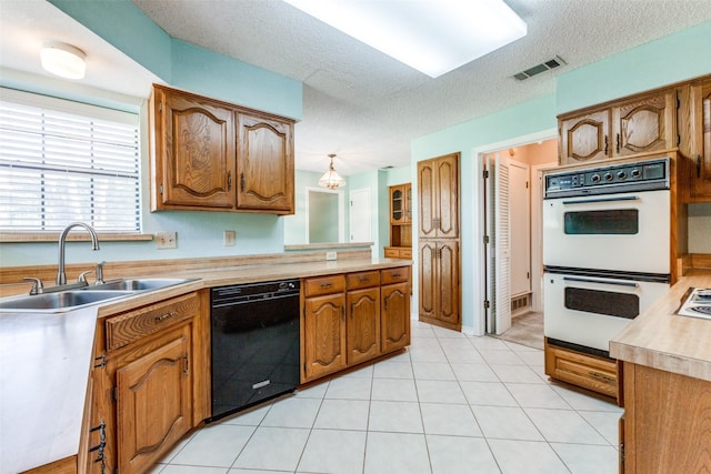 kitchen with white double oven, a textured ceiling, sink, pendant lighting, and black dishwasher