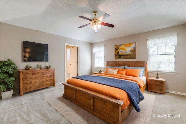 carpeted bedroom featuring ensuite bathroom, ceiling fan, and a textured ceiling