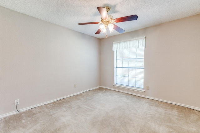 empty room with light carpet, ceiling fan, and a textured ceiling