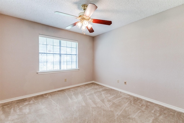 spare room featuring light carpet, a textured ceiling, and ceiling fan