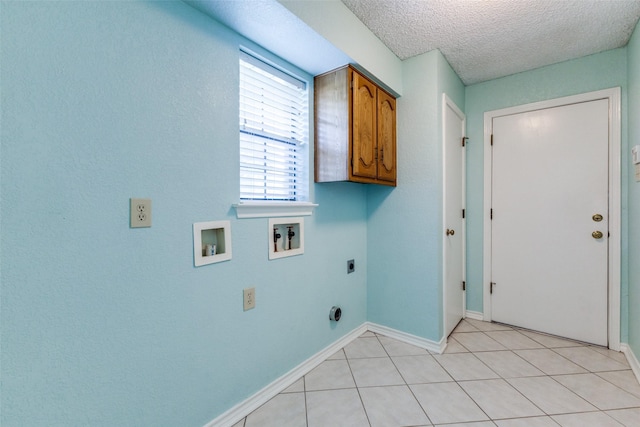 laundry area with washer hookup, cabinets, hookup for an electric dryer, a textured ceiling, and light tile patterned flooring