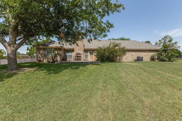 rear view of property with a lawn and central AC unit