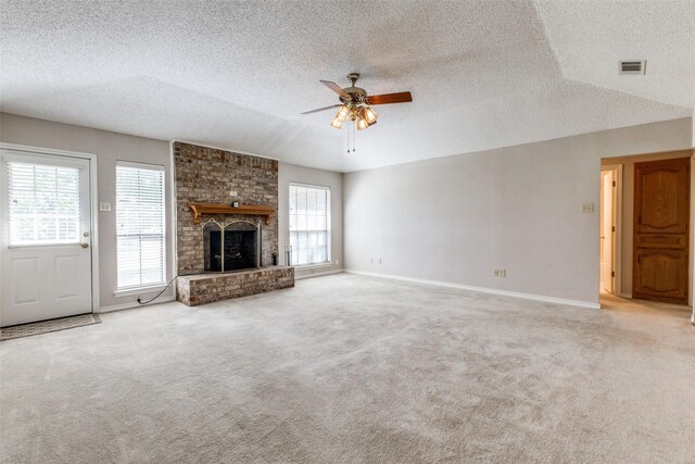 unfurnished living room featuring a fireplace, a textured ceiling, carpet flooring, and ceiling fan