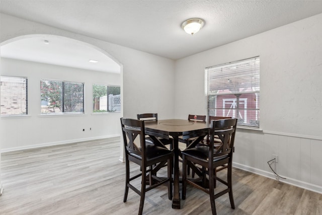 dining space with light hardwood / wood-style flooring and a textured ceiling