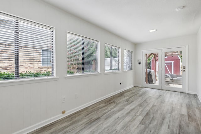 unfurnished room with french doors and light wood-type flooring