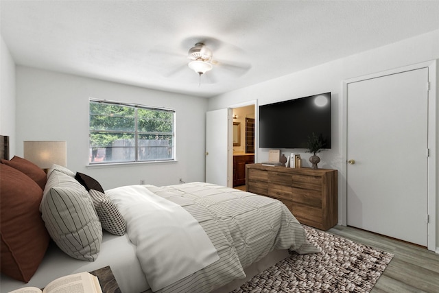 bedroom featuring connected bathroom, ceiling fan, and light wood-type flooring