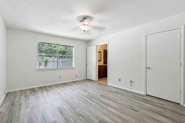 unfurnished bedroom with ensuite bathroom, a textured ceiling, ceiling fan, and light hardwood / wood-style flooring