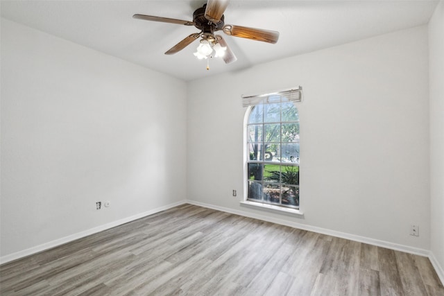 empty room with ceiling fan and light hardwood / wood-style flooring