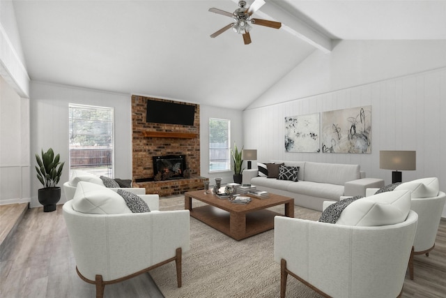 living room with lofted ceiling with beams, a fireplace, light hardwood / wood-style floors, and a wealth of natural light