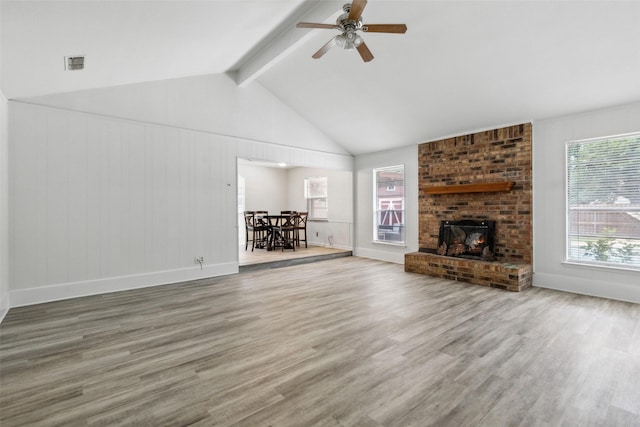 unfurnished living room featuring hardwood / wood-style flooring, ceiling fan, vaulted ceiling with beams, and a fireplace