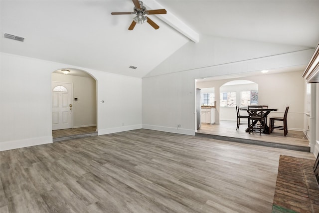 unfurnished living room featuring lofted ceiling with beams, wood-type flooring, and ceiling fan