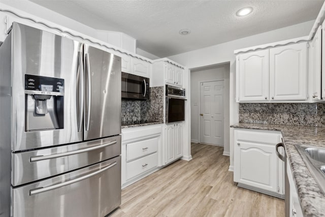 kitchen featuring stainless steel appliances, light wood-type flooring, decorative backsplash, and white cabinets