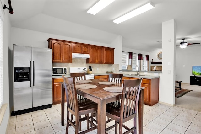 kitchen with lofted ceiling, sink, appliances with stainless steel finishes, backsplash, and light tile patterned flooring