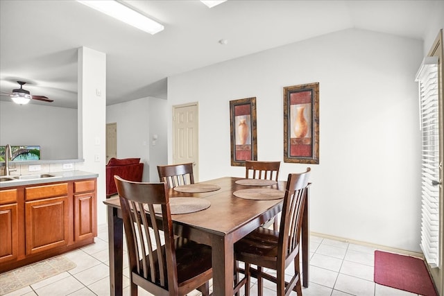 dining area with ceiling fan, sink, light tile patterned floors, and lofted ceiling