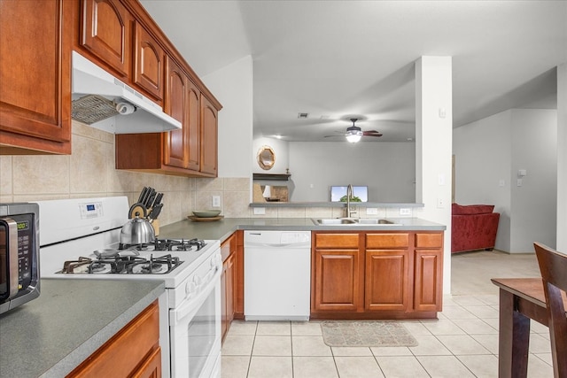 kitchen with tasteful backsplash, sink, light tile patterned floors, ceiling fan, and white appliances